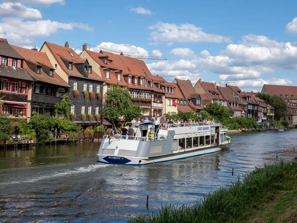 Ein Sommertag am Wasser – Ein Ausflugsschiff fährt an den Häusern von Klein Venedig vorbei.