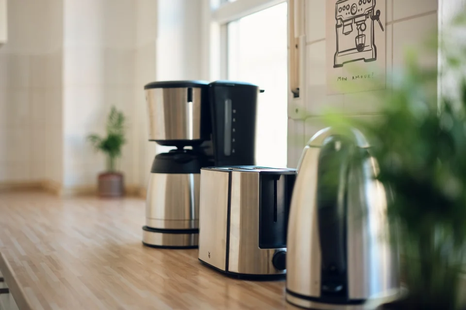 Filterkaffeemaschine und Wasserkocher stehen auf der Holzarbeitsfläche am Fenster. – Apartment Mittendrin.
