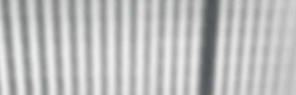Abstraktes Gestaltungsmotiv mit weichen Licht- und Schattenstreifen; keine Raumaufnahme. – Apartment Mittendrin.